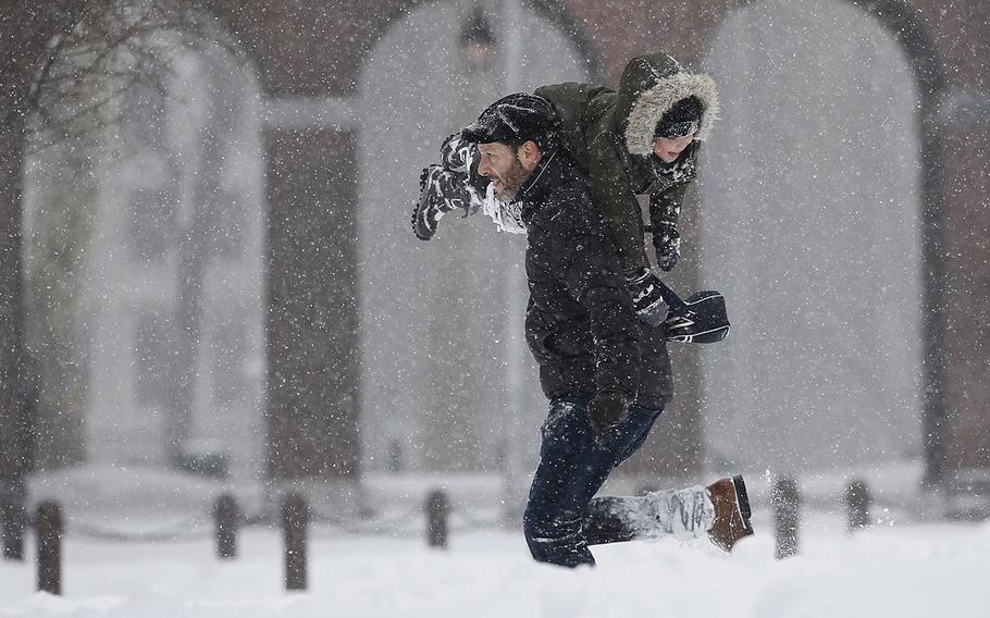 Enrique Rafalin, left, carries his nephew, Alajandro Rafalin, 5, as they play in the snow on Independence Mall, Saturday, Jan. 23, 2016, in Philadelphia.
