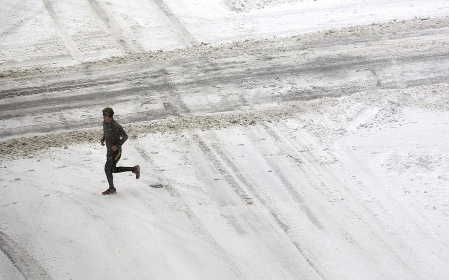 A runner crosses Salem Avenue and heads towards 3rd Street in Roanoke, Va., on Friday, Jan. 22, 2016.
