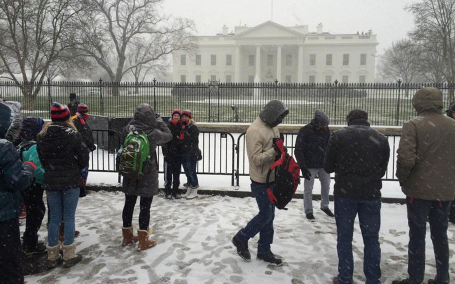 Tourists try to get in some sightseeing at the White House before the worst of a winter storm strikes the Washington, D.C., area, Jan. 22, 2016. 