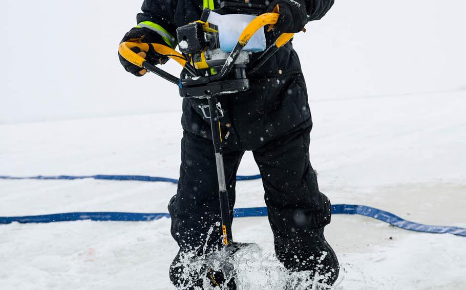 Shawn Kelly, the range maintenance foreman with the 354th Civil Engineer Squadron, uses an ice auger while constructing an ice bridge to provide access to a $20 million complex used to train pilots from around the world during RED FLAG-Alaska exercises in 2014.