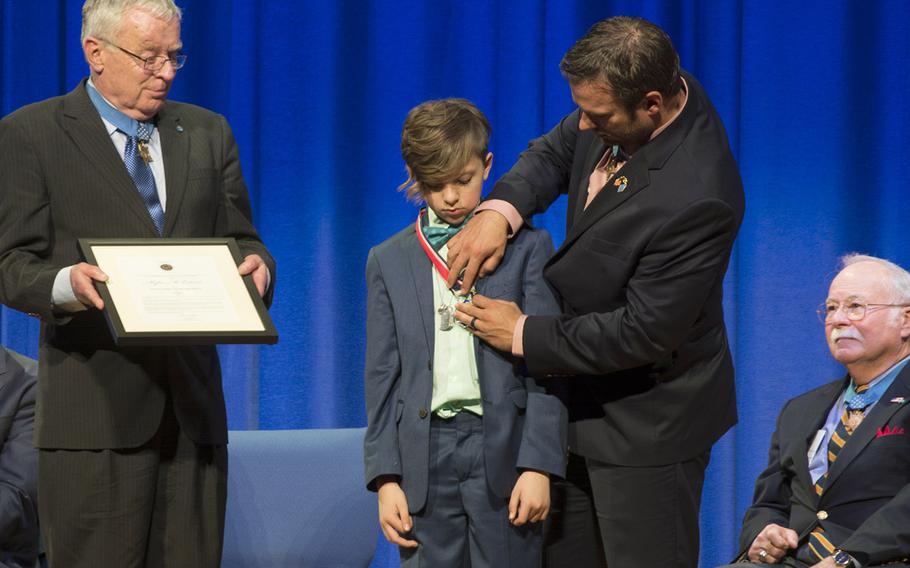 Medal of Honor recipient Edward Byers presents Myles Eckert with the Young Hero Award during a ceremony Friday at Joint Base Myer-Henderson, Va. Other Medal of Honor recipients on hand included Thomas Kelley, left, and Harvey "Barney" Barnum.