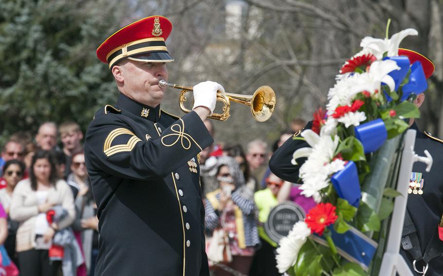 A servicemember plays the bugle during a wreath laying ceremony at the Tomb of the Unknown Soldier in Arlington National Cemetery during Medal of Honor Day, March 25, 2016.