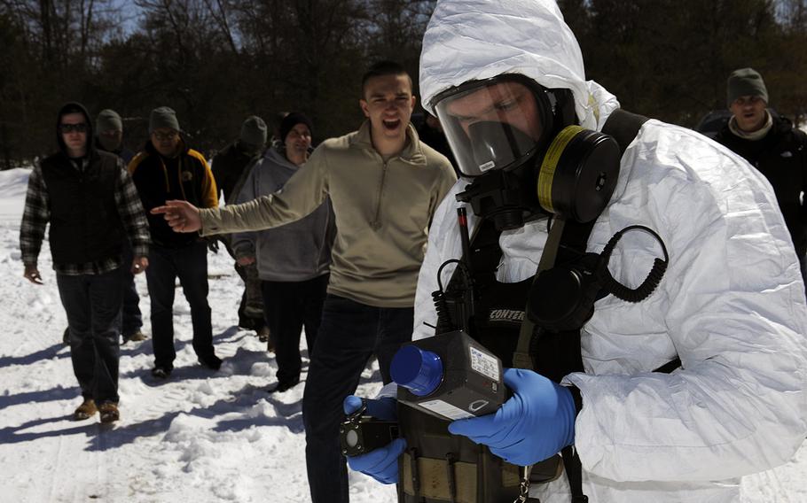 A Soldier of the 53rd Weapons of Mass Destruction Civil Support Team, Indiana National Guard, takes radiation readings with an angry mob following behind during an Arctic Eagle 16 simulated radiological dispersal device blast at Camp Grayling Joint Maneuver Training Center, Mich., April 5, 2016. 