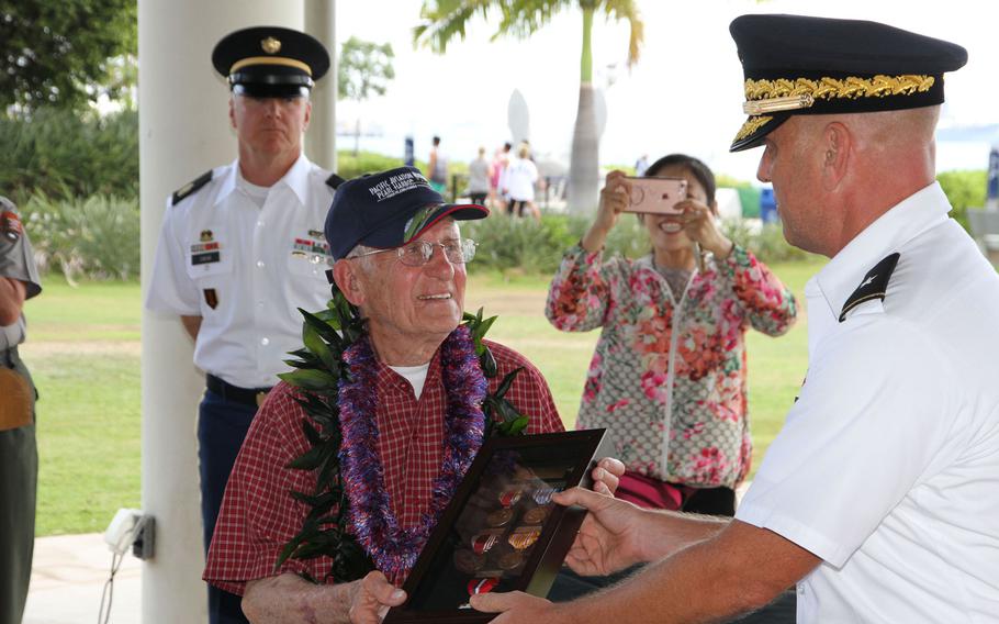 Charles Wolf, a World War II Army veteran, receives his long-overdue campaign awards from Brig. Gen. Mark Spindler, the deputy director of the Defense POW/MIA Accounting Agency at Joint Base Pearl Harbor-Hickam, during a ceremony at the Pearl Harbor Visitors Center, May 6, 2016.
