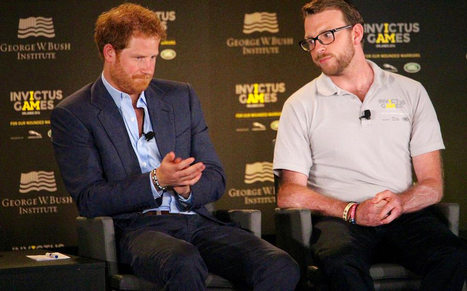 Britain's Prince Harry talks about ways to help returning servicemen who have suffered traumatic injuries on the battlefield as Lance. Cpl. John-James Chalmers, formerly of the Royal Marines Commando, listens during the 2016 Invictus Games Symposium on Invisible Wounds, Sunday, May 8, 2016 at Orlando, Fla.
