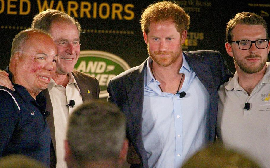 From left, Master Sgt. Israel Del Toro, Jr., former President George W. Bush, Britain's Prince Harry and Lance Cpl. John-James Chalmers, formerly of the Royal Marines Commando, pose for pictures after speaking on a panel at the 2016 Invictus Games Symposium on Invisible Wounds, Sunday, May 8, 2016 at Orlando, Fla.