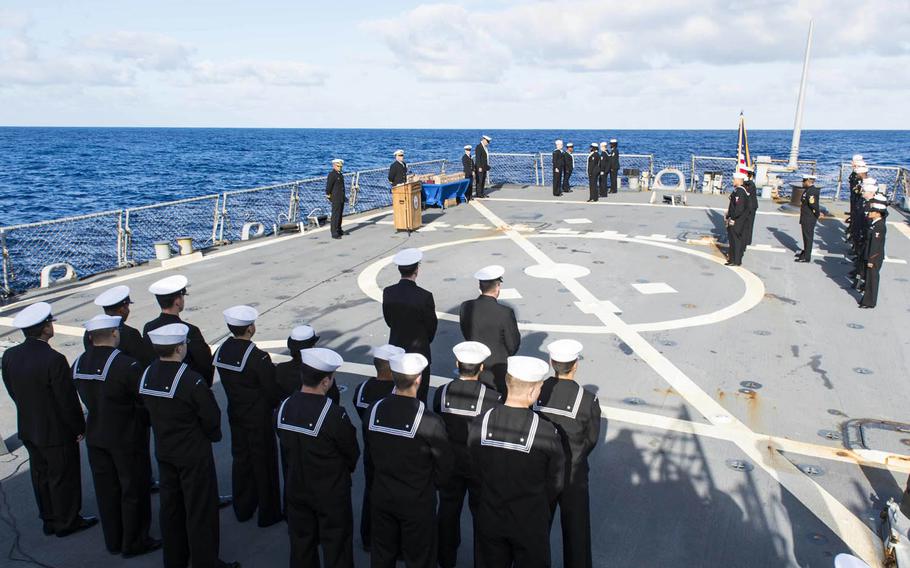 Sailors assigned to the guided-missile destroyer USS Stout conduct a burial-at-sea service on the flight deck, Sunday, May 22, 2016. Twenty veterans and dependents were remembered during the ceremony.