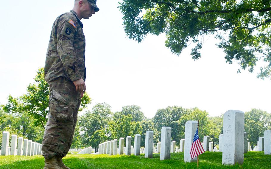 Capt. Andrew McDaniel stands at the grave of his grandfather, Maj. Earl McDaniel, during Flags In at Arlington National Cemetery, May 26, 2016.