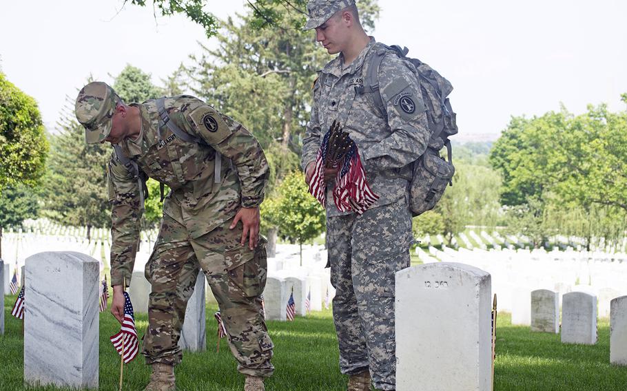 Pfc. Mike Almeria, left, and Spc. Travis Zapata participate in Flags In at Arlington National Cemetery on May 26, 2016.