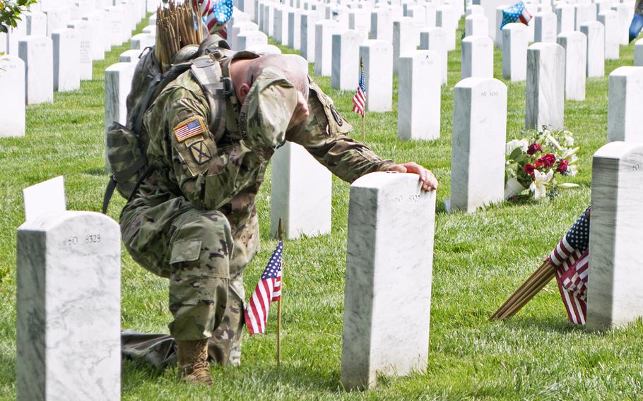 Lt. Col. Ryan Morgan pauses at the grave of U.S. Army Capt. Ian Patrick Weikel during Flags In at Arlington National Cemetery, May 26, 2016.