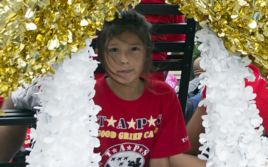 Catherine Gonzales, 8, underneath a giant gold star on the Tragedy Assistance Program for Survivors (TAPS) float. Her father, Marine Sgt. Adan Gonzales Jr., died in Afghanistan in 2011 during a firefight with the Taliban.