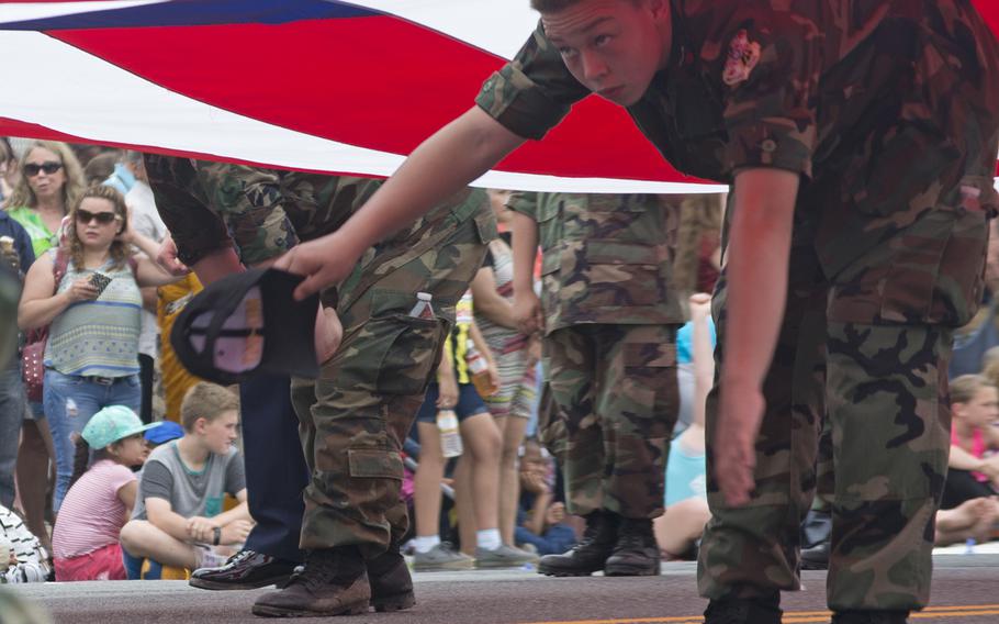 A boy holds up a very large American flag during the 2016 Memorial Day Parade in Washington, D.C.