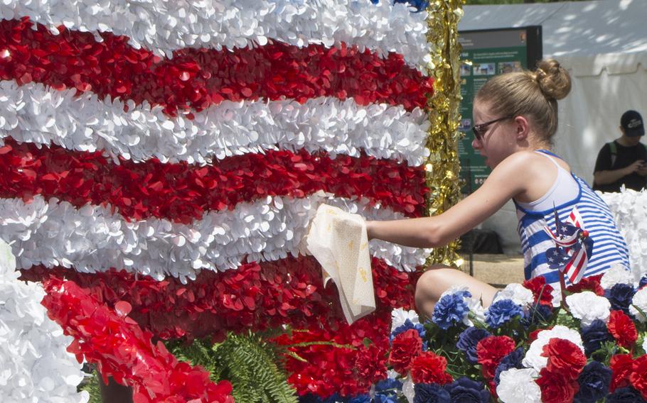 A young girl cleans part of a float before the start of the 2016 Memorial Day Parade in Washington, D.C.