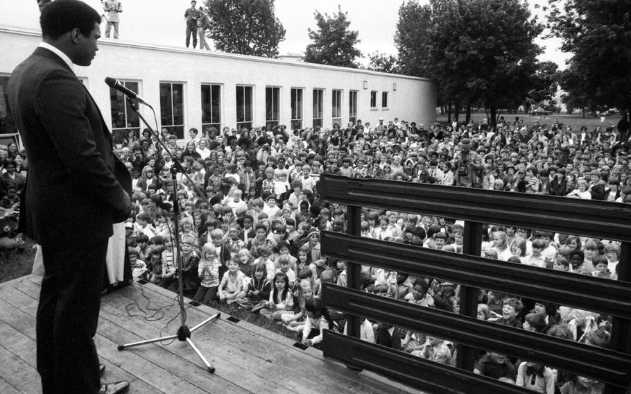 Muhammad Ali talks to a crowd of more than 1,200 fascinated schoolkids at the Augsburg American School in May, 1976. After visiting the school, Ali attended a race-relations class where he lectured on the need for mankind to return to the teachings and abide by the laws of God.