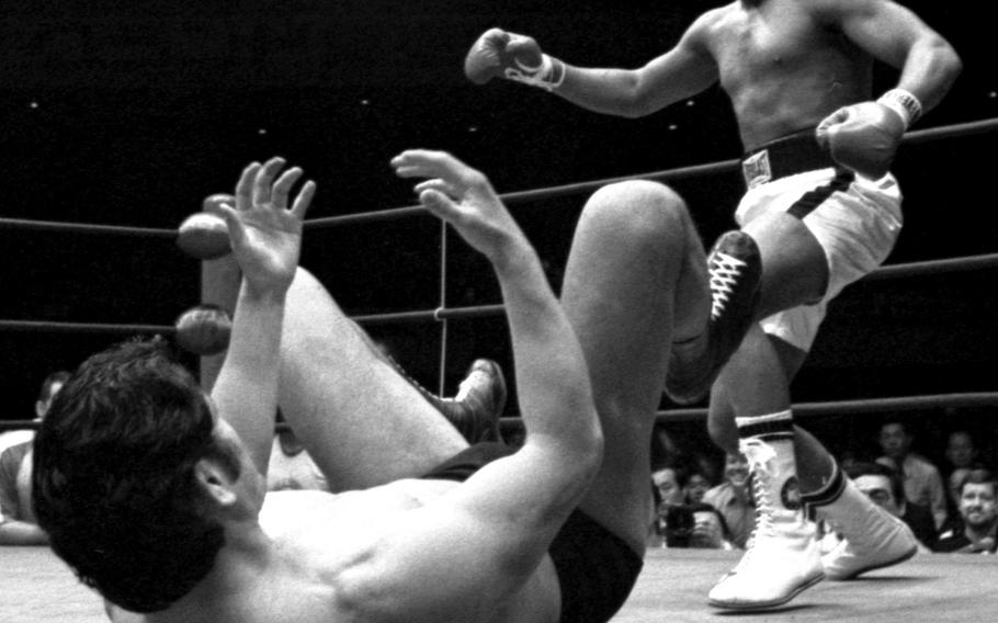 Antonio Inoki challenges Muhammad Ali to get down on the mat during an exhibition (billed as the "World Martial Arts Championship") between the heavyweight boxing champ and the Brazilian-Japanese pro wrestler at Tokyo's Budokan Hall in June, 1976. The match, which consisted mostly of Inoki lying on the mat attempting to deliver kicks to the thigh, wasn't exactly a bright spot on Ali's record. One Stripes reporter called it a farce, while another said "the best thing that can be said about it was that it ended." Ali was paid about six million dollars and Inoki three million; Angelo Dundee, Ali's trainer, said beforehand that he was "gonna grab the money and run like a thief in the night."