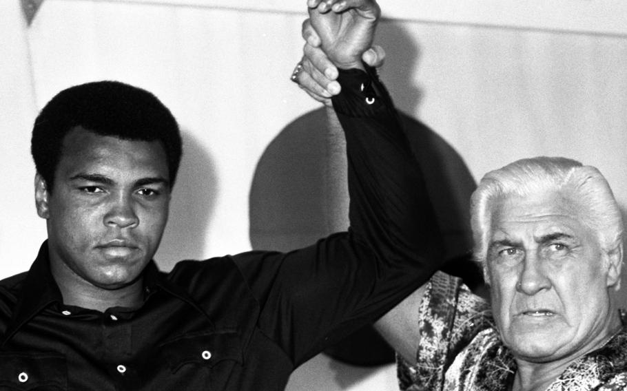 Muhammad Ali poses with pro wrestler Fred Blassie, one of his advisors for his exhibition match with wrestler Antonio Inoki in Tokyo in June, 1976.