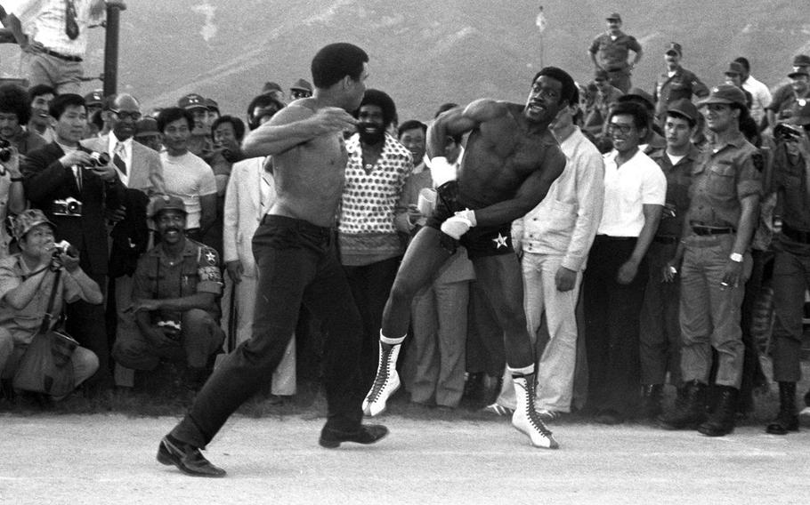 Muhammad Ali,  during a visit with 2nd Infantry Division troops at the Shoonover Bowl outdoor theater, near the Korean DMZ, in June, 1976. Ali, who had recently taken part in a boxing-wrestling match against Antonio Inoki in Tokyo, was greeted by thousands of Koreans who lined his motorcade route from the airport to Seoul.