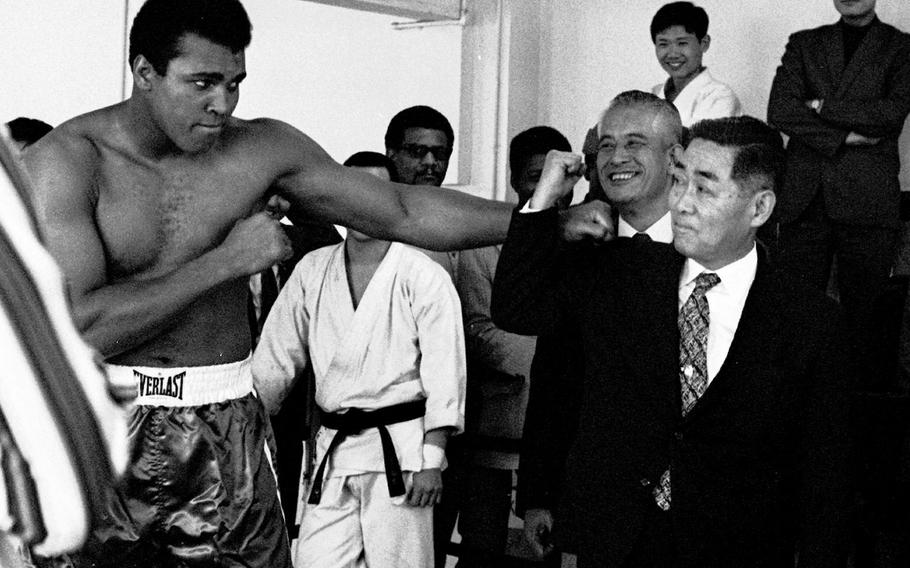 Muhammad Ali jokes with dignitaries as he works out at Tokyo's Tanabe Gym in preparation for his upcoming fight with Mac Foster in 1972. He beat Foster in 15 rounds.