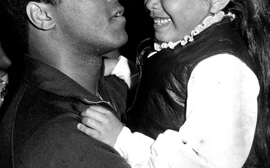 Muhammad Ali meets a young fan during a visit to Yokota Air Base in March, 1972,  a few days before his fight with Mac Foster in Tokyo. A crowd of about 4,500 turned out to hear Ali deliver a series of his famed one-liners, poetic predictions of a victory over Foster, and the usual insults directed at Joe Frazier.