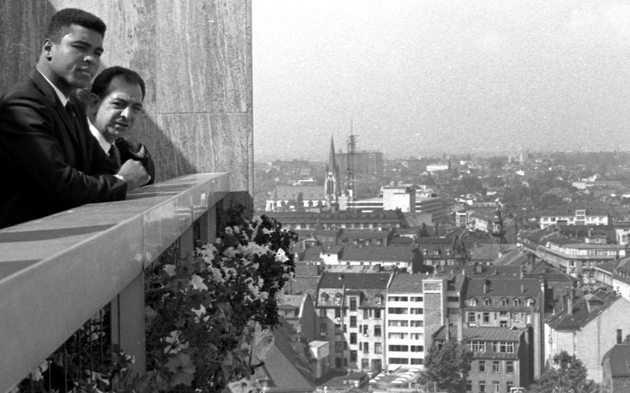 Muhammad Ali and his trainer, Angelo Dundee, look out at the city of Frankfurt, West Germany, in August, 1966. Ali was to defend his heavyweight boxing title against European champion Karl Mildenberger in mid-September.