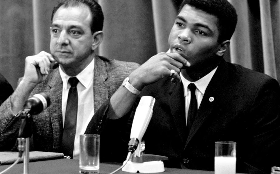 Muhammad Ali, during a press conference at the Intercontinental Hotel in Frankfurt, West Germany, in August, 1966. With him is his longtime trainer, Angelo Dundee. Ali was to defend his heavyweight boxing title against European champion Karl Mildenberger in mid-September.