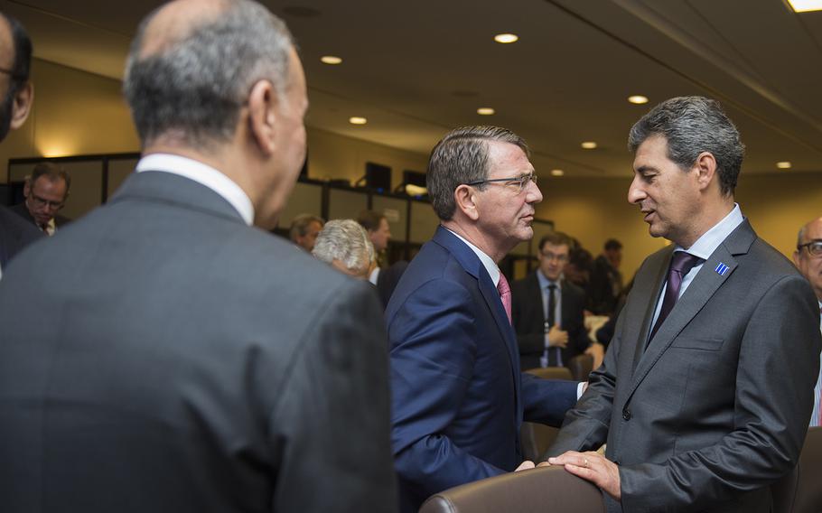 Secretary of Defense Ash Carter, middle, and Iraqi Minister of Defense Khalid Al Obaidi, left, greet Romanian Minister of Defense Mihnea Motoc during a meeting of defense ministers of the Global Coalition to Counter ISIL July 20, 2016, at Joint Base Andrews, Md. 