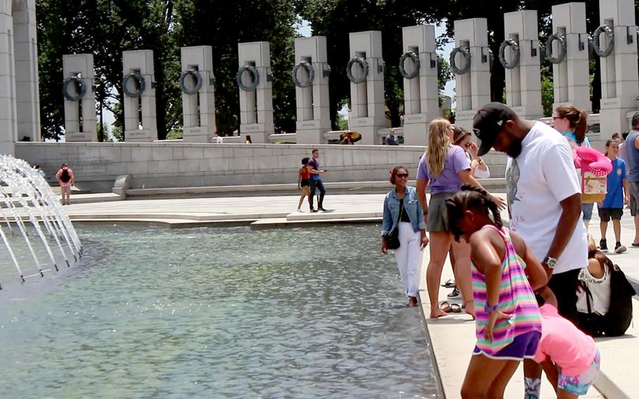 A few people take a dip while visiting the World War II Memorial pool at the National Mall in  Washington, D.C., on July 21, 2016.