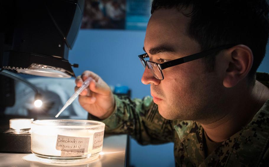 U.S. Navy Lt. Alister Bryson, an entomologist assigned to Naval Environmental Preventive Medicine Unit 2, experiments with a new tile-based insecticide in Honduras. The medical team partnered with Operation Blessing as they attempt to use biological methods to combat the zika virus.