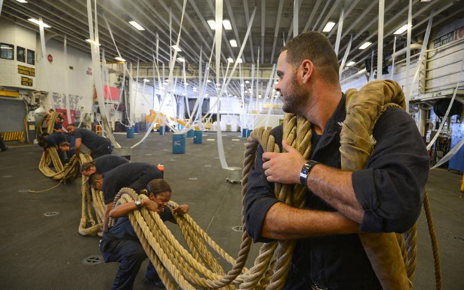 Boatswain’s Mate 3rd Class Ahmed N. Abdarbo leads a group of Sailors transporting a bundle of shifting lines through the hangar bay aboard amphibious assault ship USS Iwo Jima (LHD 7). Iwo Jima is returning to her homeport of Mayport, Fla. following exercise Bold Alligator 2016.
