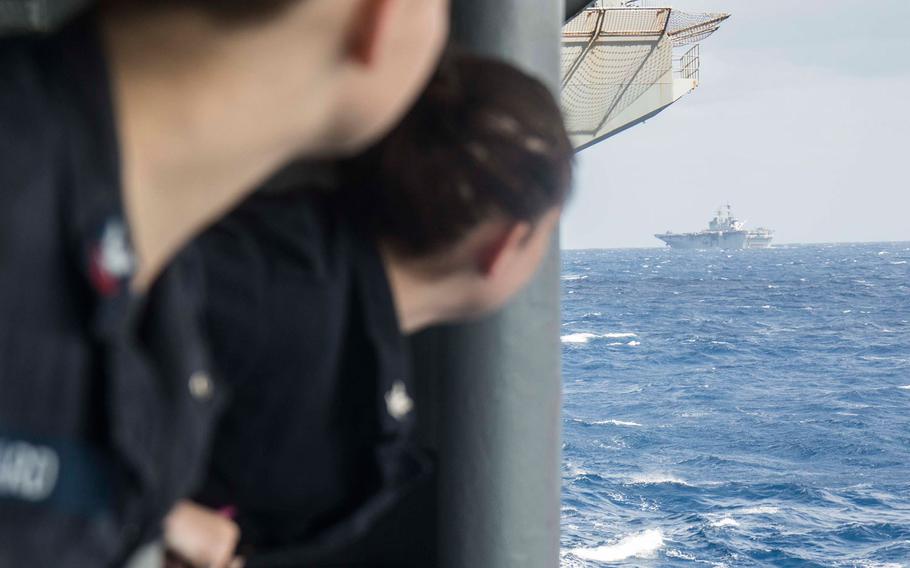 Petty Officer 2nd Class Ruby Ward, left, from Englewood, Florida, and Petty Officer 3rd Class Samantha Quinonez, from Chicago, Illinois, watch as the amphibious assault ship USS Iwo Jima (LHD 7) approaches the aircraft carrier USS George Washington (CVN 73) on Oct 10, 2016. 