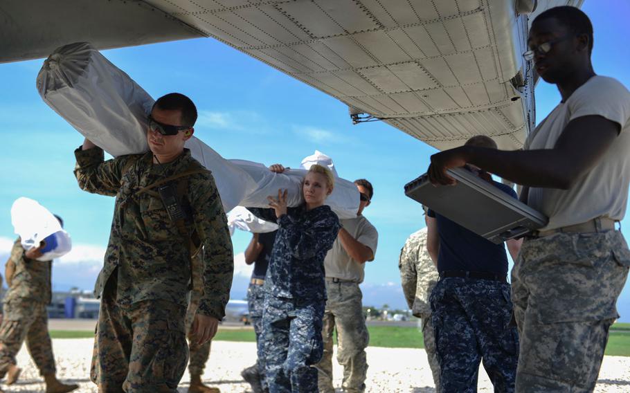 Service members attached to Joint Task Force (JTF) Matthew load supplies onto a CH-53E Super Stallion, assigned to Marine Medium Tiltrotor Squadron 365 (VMM-365), for aid delivery. JTF Matthew is providing humanitarian aid and disaster relief to Haiti following Hurricane Matthew.