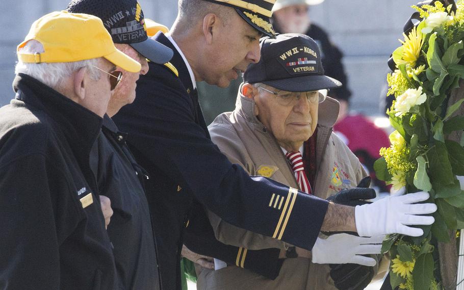 World War II veteran Robert Reid helps place a wreath during a Veterans Day ceremony at the National World War II Memorial in Washington, D.C., Nov. 11, 2016.
