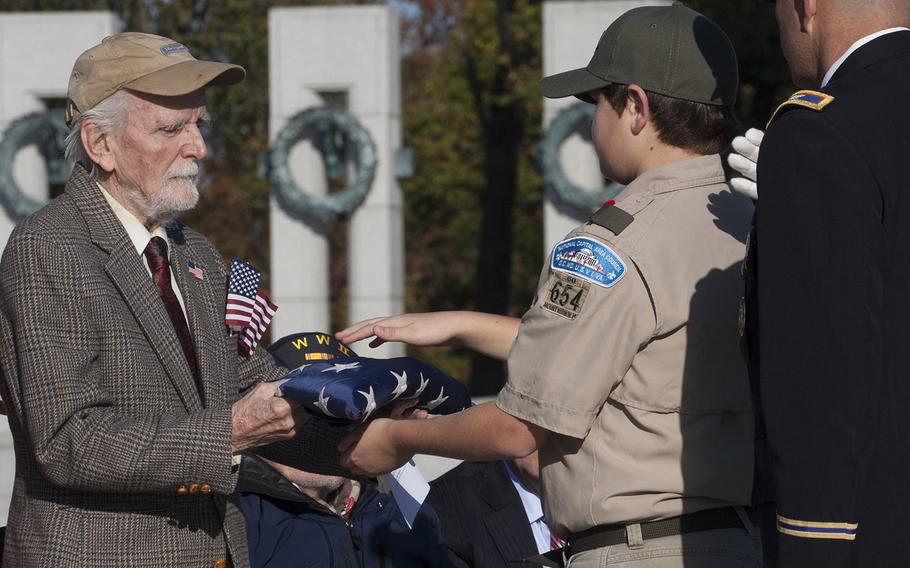 World War II veteran Paul Hoskins accepts a flag during a Veterans Day ceremony at the National World War II Memorial in Washington, D.C., Nov. 11, 2016.