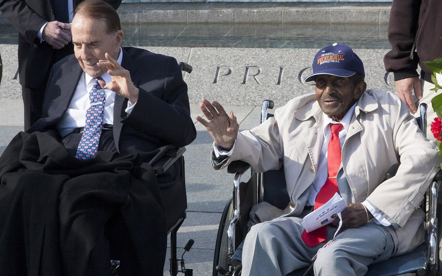 World War II veterans former Sen. Bob Dole and Garnet W. Hammond wave to visitors after they took part in a Veterans Day wreath-laying ceremony at the National World War II Memorial in Washington Friday morning. Dole, the former Senate majority leader, still greets Honor Flight participants at the memorial on Saturday mornings. Hammond, a resident of Temple Hills, Md., was employed by the U.S. Postal Museum for 35 years.