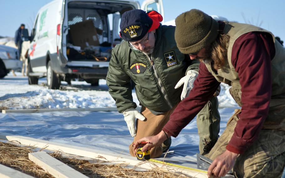 Wilbur Hilton, a 61-year-old veteran from Flint, Mich., helps to measure two-by-fours for barracks at one of the Oceti Sakowin Camp, a Dakota Access Pipeline protest camp, on Saturday, Dec. 3. Hilton has the help of Sean Mercer, a nonveteran protester. Hilton said the drinking water crisis in Flint motivated him to help the Sioux tribe protect Lake Oahe. 