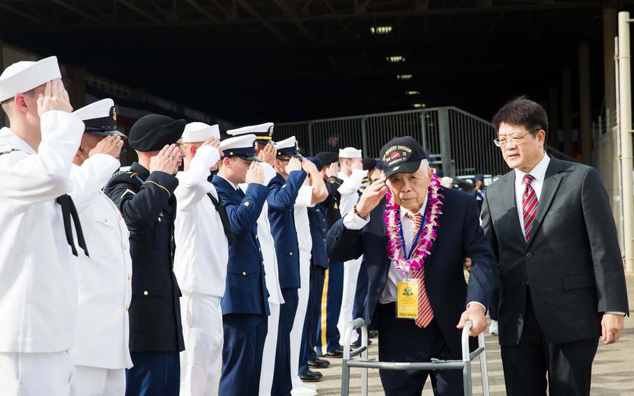 World War II veteran Daniel Lau returns the salute of an honors cordon as he departs the ceremony commemorating the 75th anniversary of the attack on Pearl Harbor, Wednesday, Dec. 7, 2016, at Joint Base Pearl Harbor-Hickam, Hawaii.