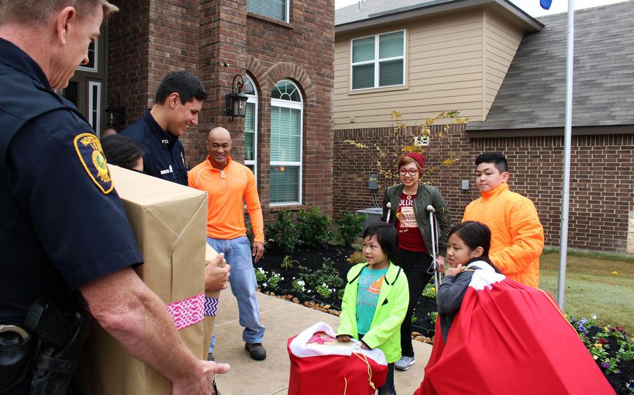 San Antonio first-responders bring gifts for the children of Air Force Lt. Col. Kato Martinez, top center.