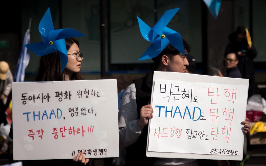 Protesters march by the U.S. Embassy at Gwanghwamun Square, Seoul, South Korea, Saturday, March 11, 2017.