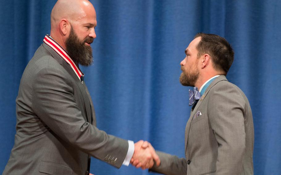 Travis Ellis, left, shakes hands with Medal of Honor recipient Clinton Romesha on Saturday, March 25, 2017. Ellis received the Citizens Honors Award, the highest given by the Congressional Medal of Honor society, for his work in combating PTSD and traumatic brain injury in servicemembers.  