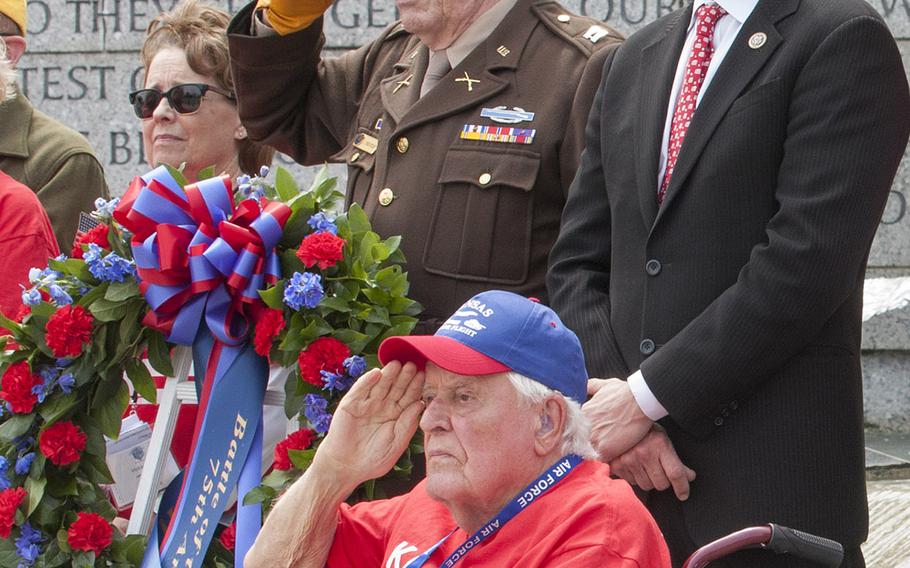 Rep. Roger Marshall, R-Kan., at right, closes his eyes during taps while WWII, Korea and Vietnam veteran Ewin Aley, foreground, salutes at the Battle of the Coral Sea 75th Anniversary at the World War II Memorial in Washington, D.C., on May 4, 2017.