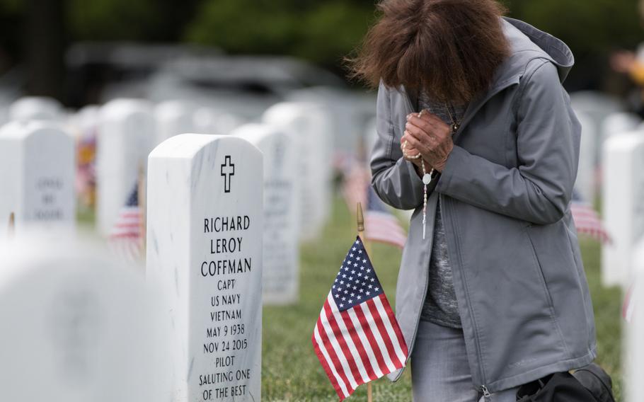 J’Neane Coffman prays at the grave marker of her husband, Richard “Skip” Coffman, during Flags In at Arlington National Cemetery on May 25, 2016.