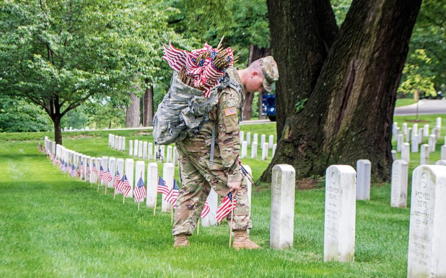 A soldier with the 3rd U.S. Infantry Regiment (The Old Guard) places a flag at Arlington National Cemetery during the Flags In on May 25, 2017. Flags In has taken place every year since The Old Guard was designated as the Army's official ceremonial unit in 1948.