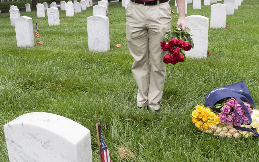 U.S. Army 2nd Lt. Chris Kimrey salutes after placing a rose at an Arlington National Cemetery grave during an event organized by the Memorial Day Flowers Foundation on Sunday, May 28, 2017.