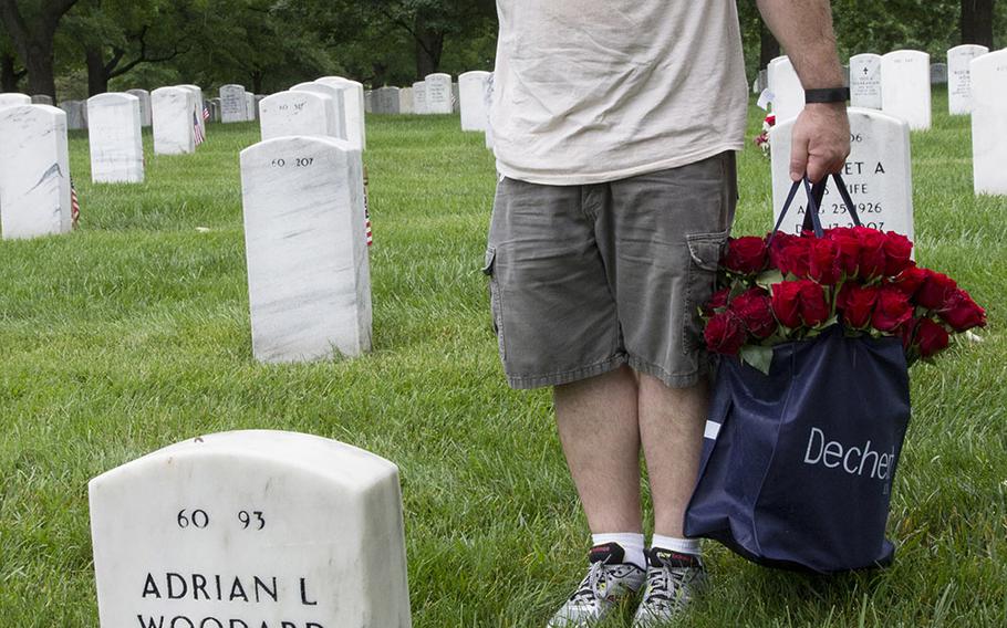 A veteran salutes after placing a rose at an Arlington National Cemetery grave during an event organized by the Memorial Day Flowers Foundation on Sunday, May 28, 2017.