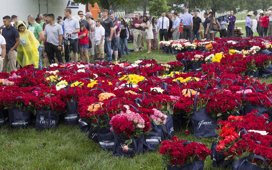 Volunteers line up for roses to be placed at Arlington National Cemetery graves during an event organized by the Memorial Day Flowers Foundation on Sunday, May 28, 2017.