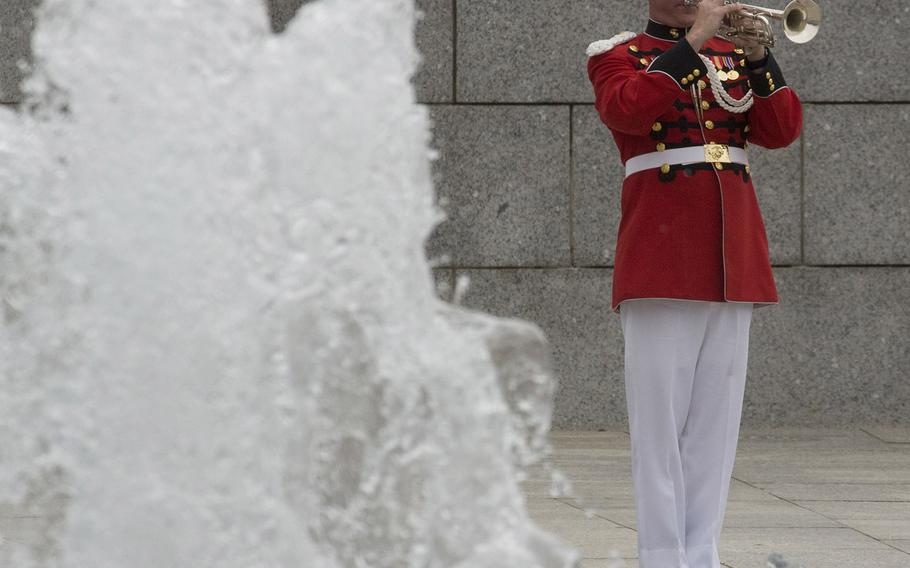 With a fountain at the National World War II Memorial in Washington, D.C., in the foreground, a bugler plays taps at the Memorial Day ceremony on May 29, 2017.