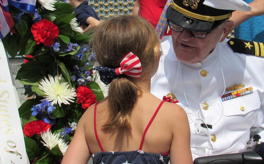 Jim Downing, a 103-year-old World War II Navy veteran, speaks with a young girl following the Memorial Day event at the World War II Memorial in Washington on Monday, May 29, 2017. Downing is the second oldest living Pearl Harbor survivor.