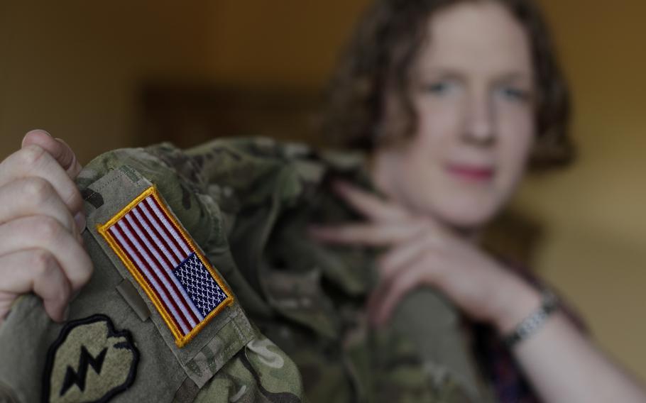 In this July 29, 2017, photo, transgender U.S. Army Capt. Jennifer Sims lifts her uniform during an interview with The Associated Press in Beratzhausen near Regensburg, Germany. 