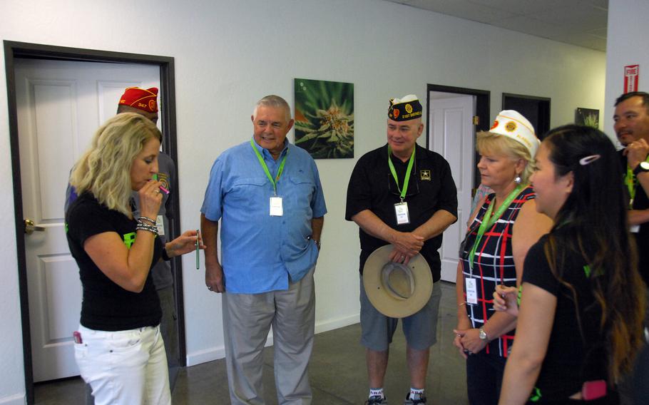 Alise Dalrymple, left, takes a typical "dose" of marijuana from a vaporizer pen at Nevada Botanical Science in Reno, Nev. on Wednesday, Aug. 23. American Legion members Wayne Stacey, Ron Bradstreet and Donna Stacey, watch.