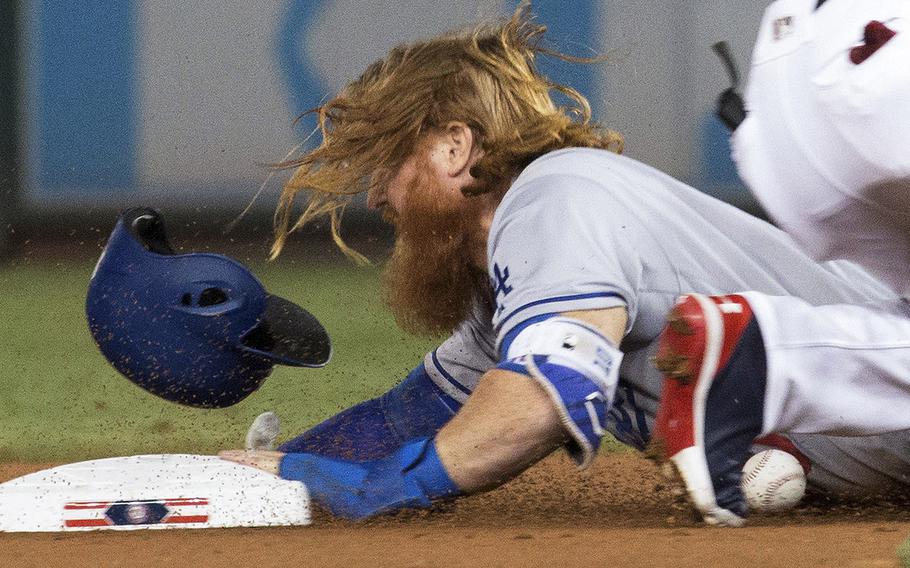 Justin Turner of the Los Angeles Dodgers slides safely into second with a stolen base as the ball gets away from Washington Nationals shortstop Trea Turner at Nationals Park, Sept. 17, 2017.